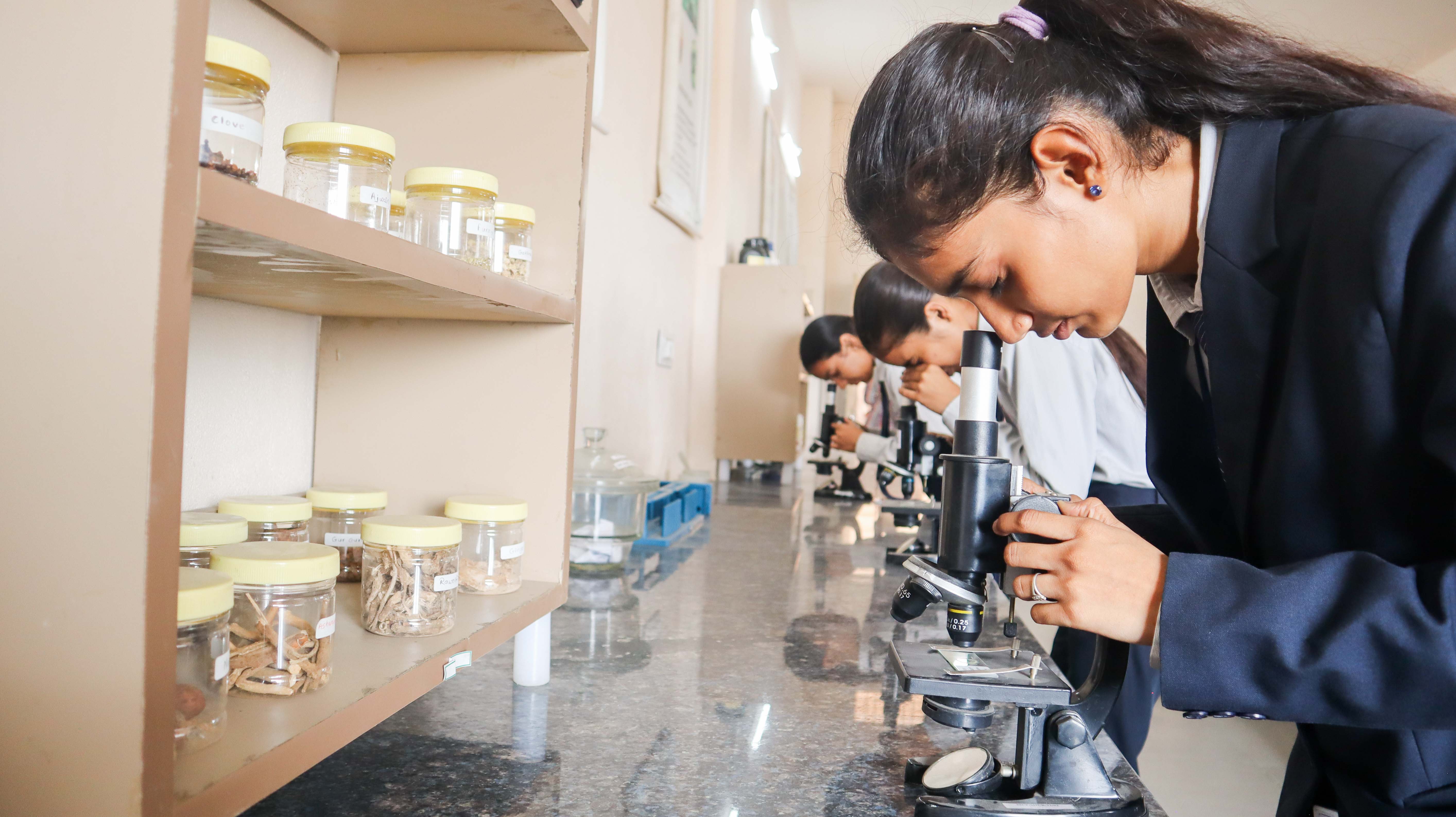 Students performing experiments in the pharmacy laboratory at Manwatkar College of Pharmacy